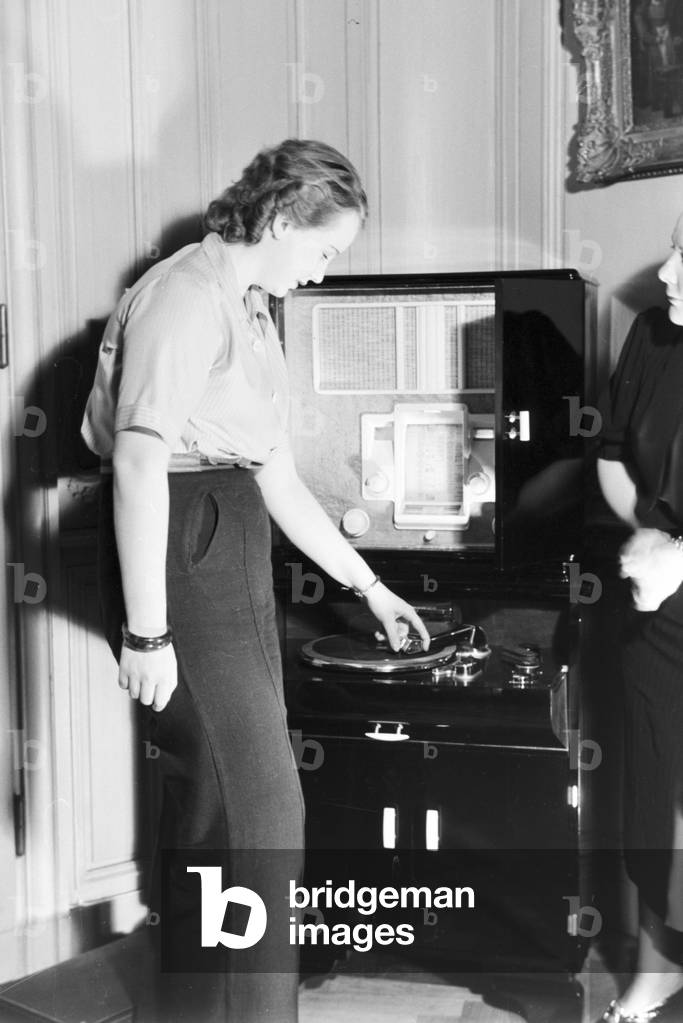 At the radiogram: the princess of carnival in Mainz 1938, on the occasion of the 100th anniversary of the leading local carnival association, at home with her mother in Nieder-Olm (b/w photo)