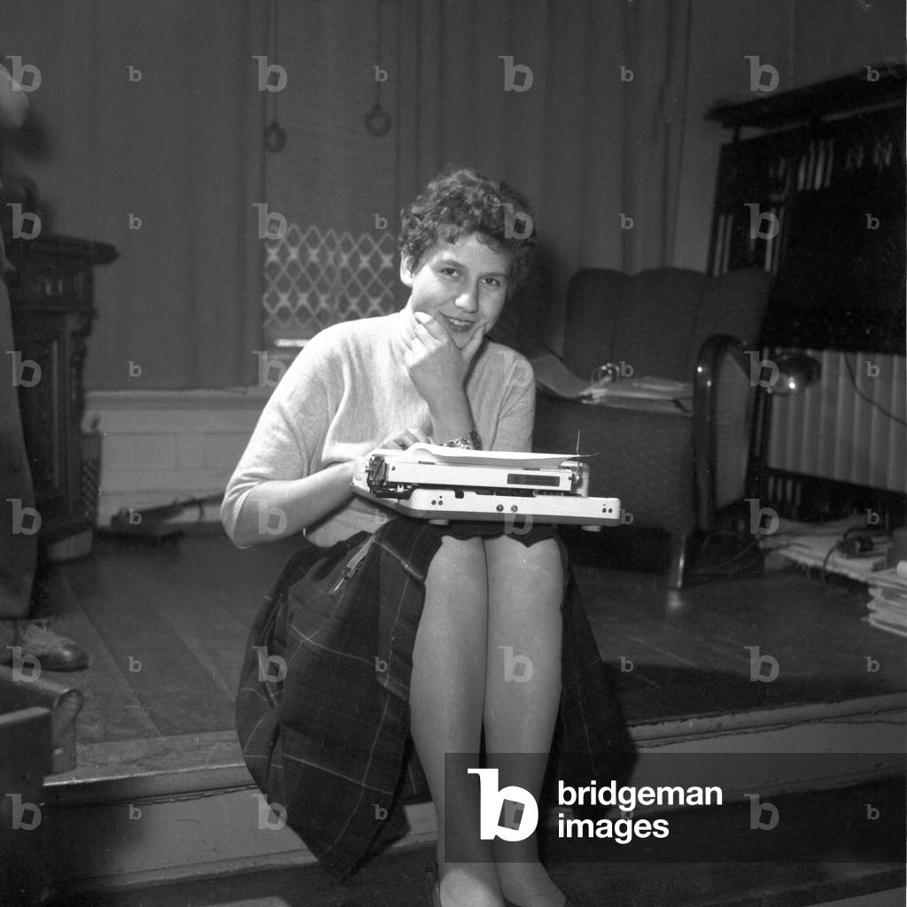 A woman with a portable typewriter on her knees, Germany 1955