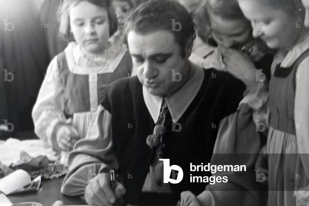 A opera singer signing autographs in the opera in Rome, Italy 1940s (b/w photo)