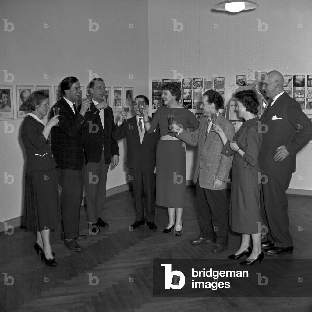 Officials and staff members clinking glasses for a good run of a lottery, Germany 1950s