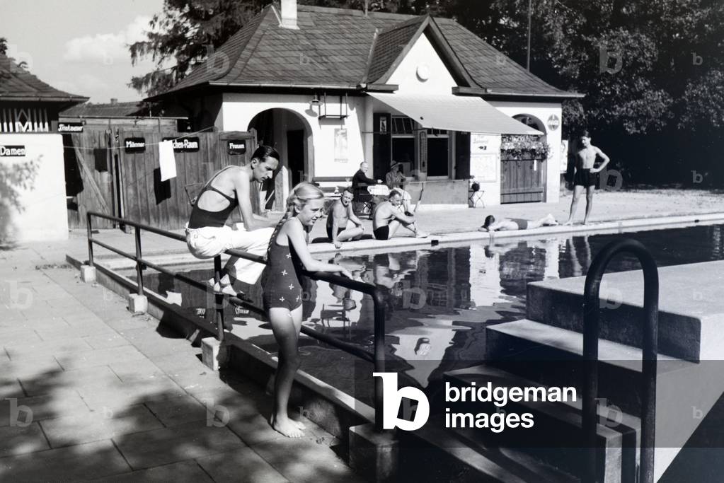 Visitors are enjoying the sunshine at the pool of the swimming bath in Bad Blankenburg, Germany 1930s (b/w photo)