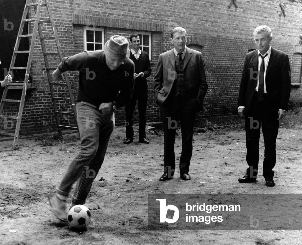 German TV and movie director Juergen Roland and actors Guenther Stoll and Guenther Neutze playing football while a production break, Germany 1967