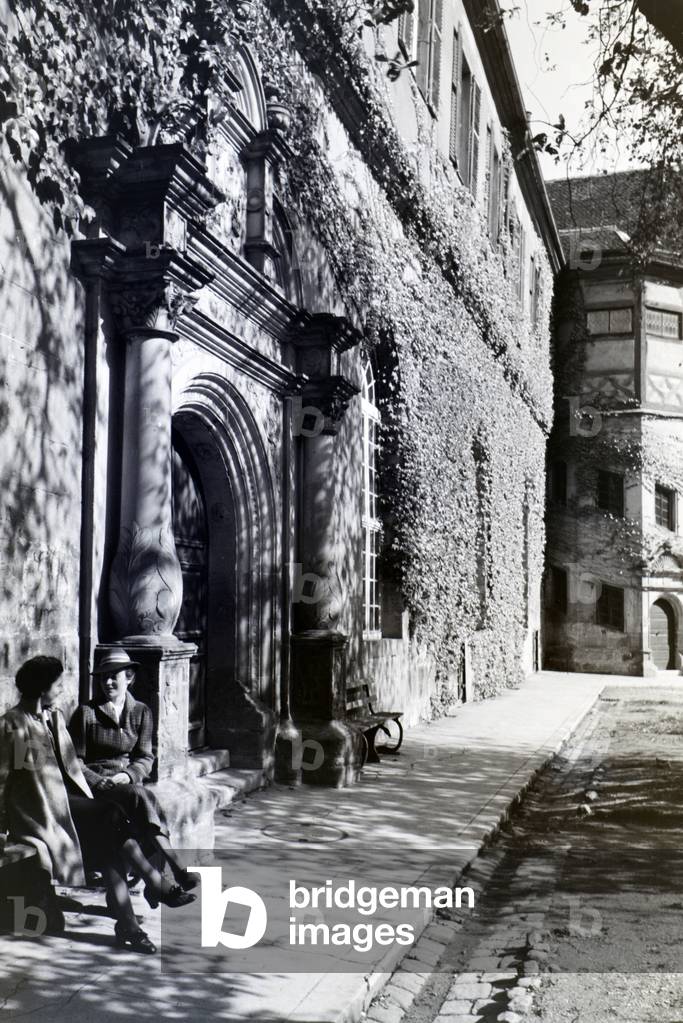 Two young ladies taking a walk in the patio of the Hohentübingen castle, Tübingen, Germany 1930s (b/w photo)