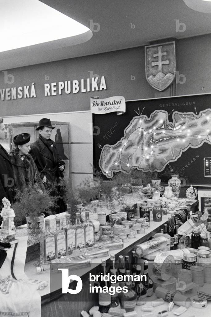 Visitors of the Leipziger Frühjahrsmesse at a stand with traditional delicacy from Slovakia, Germany 1941 (b/w photo)