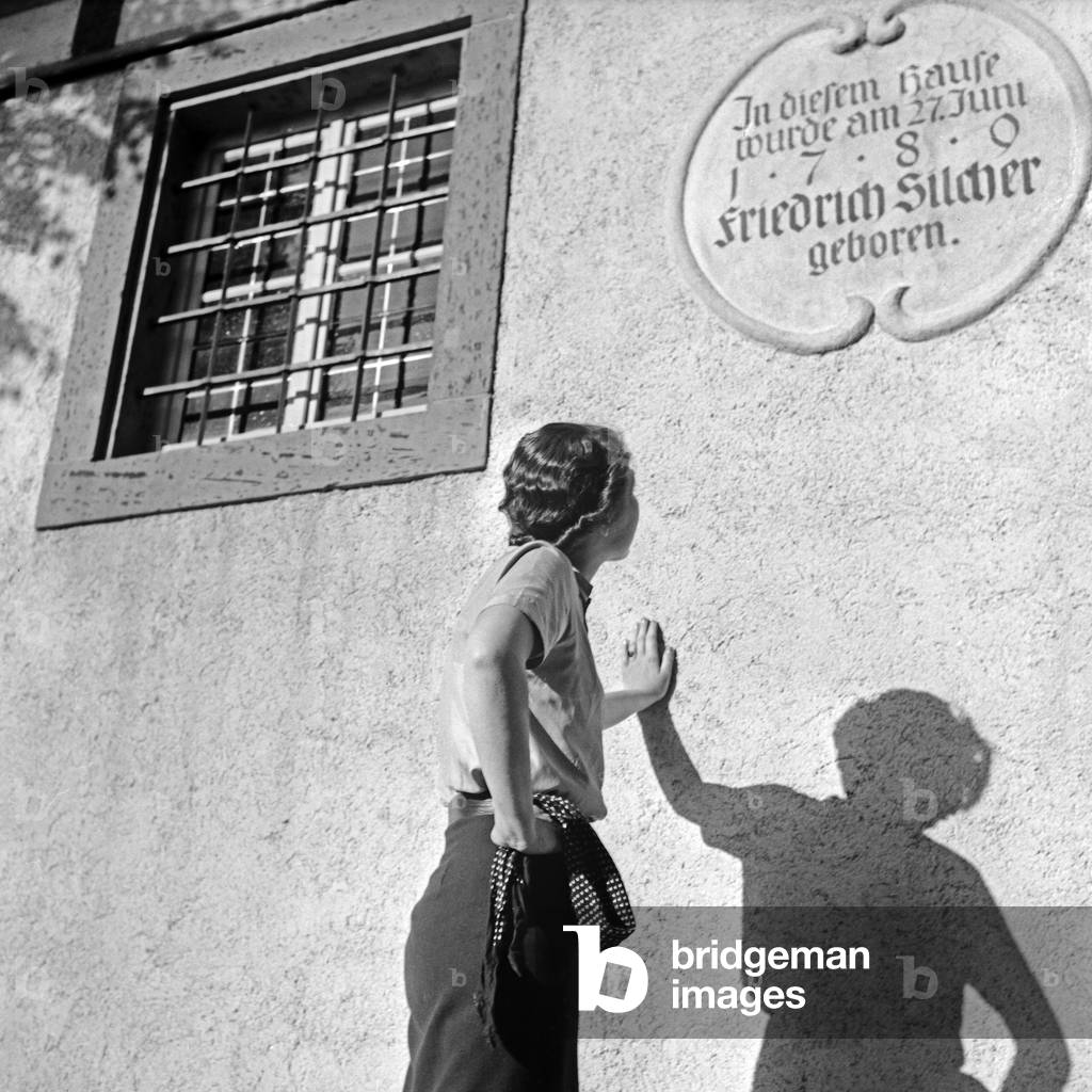 A young woman leaning at the house at Schnait where German composer Philipp Friedrich Silcher was born, Germany 1930s (b/w photo)