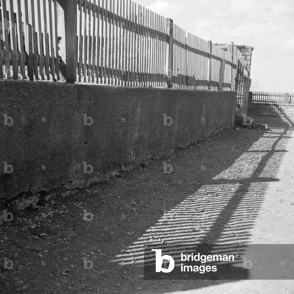 Light and shadow from a fence on a village path, Germany 1930s (b/w photo)