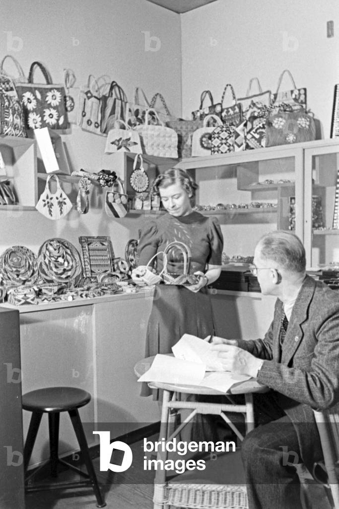 Staff members on a booth for basketry with exhibits and order book, Germany 1940s (b/w photo)
