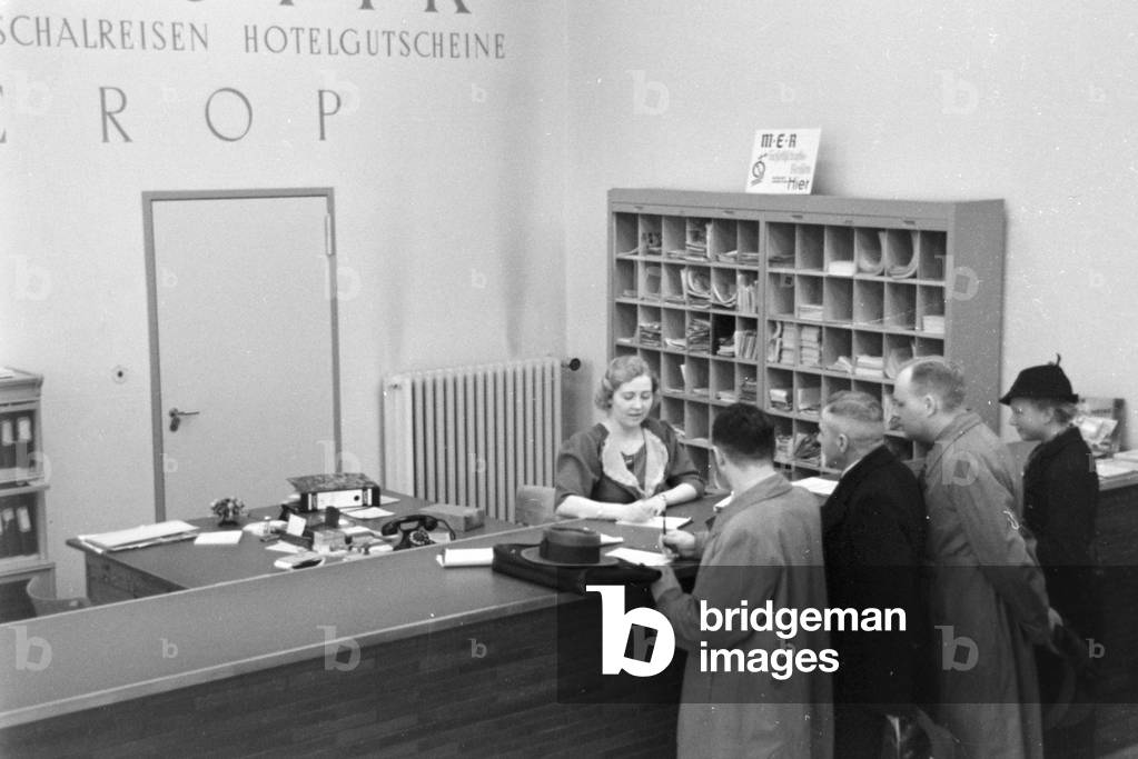 Travellers and staff members at a huge office of a travel agency in Berlin, Germany 1930s (b/w photo)