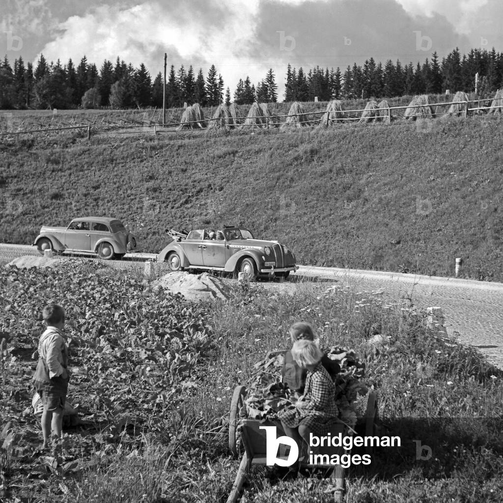 Countryside children watching to cars passing by, Austria 1930s (b/w photo)