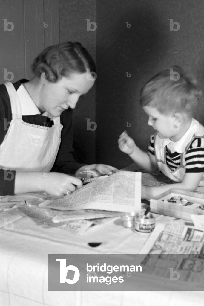 Mother and child doing handicrafts, Germany 1930s (b/w photo)