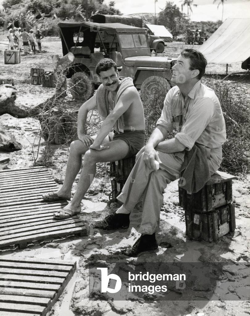 American actor Gregory Peck chatting with R.A.F. aviator while a break at the production of his movie 