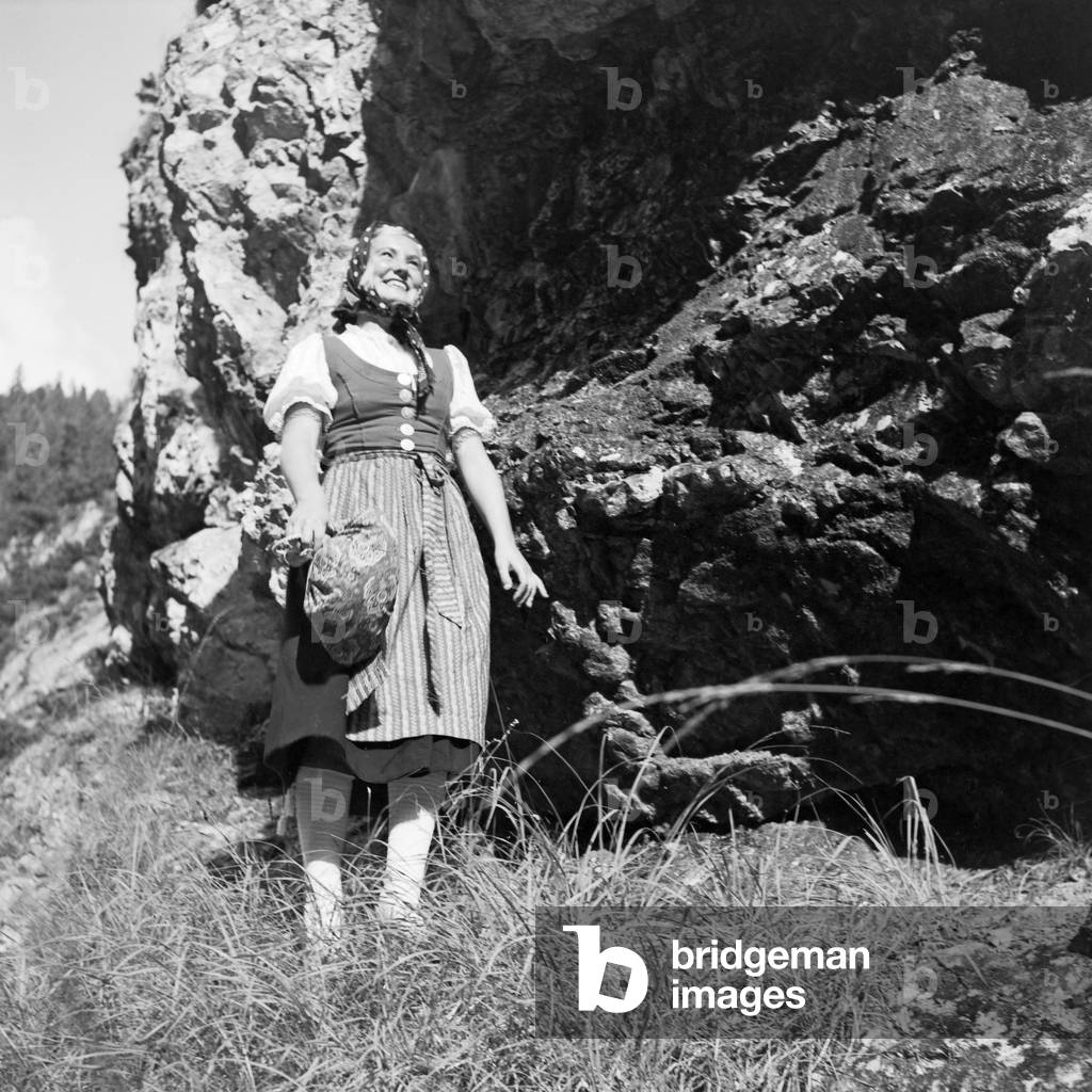 A young woman climbing on a mountain in the Wachau area in Austria, Germany 1930s (b/w photo)