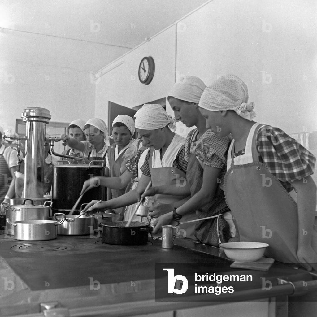 BdM girls learning how to cook at the kitchen of the school for home economics at Greifenberg, Germany 1930s (b/w photo)