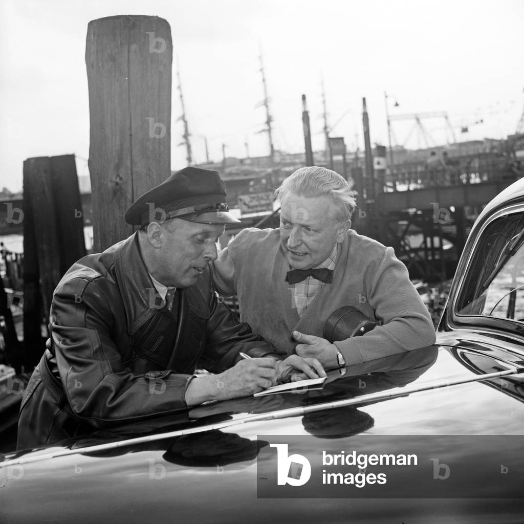 German lutenist Richard Germer gets a quittance from a taxi driver at Hamburg, Germany 1950s