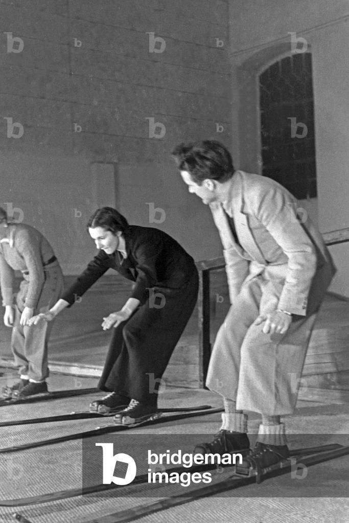 A skiing teacher at a lesson with femals skiing beginners, Germany 1930s (b/w photo)