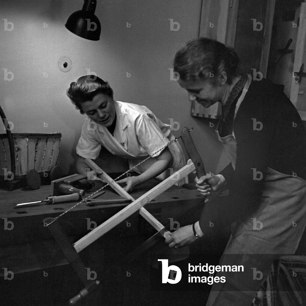 First steps to carpentry at a mother training of the Reichsmuetterdienst, Germany 1930s (b/w photo)