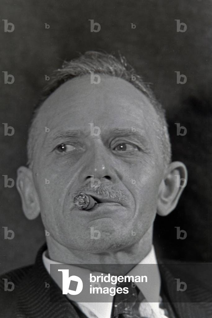 A man smoking a cigar for an advertising campaign, Germany 1930s (b/w photo)