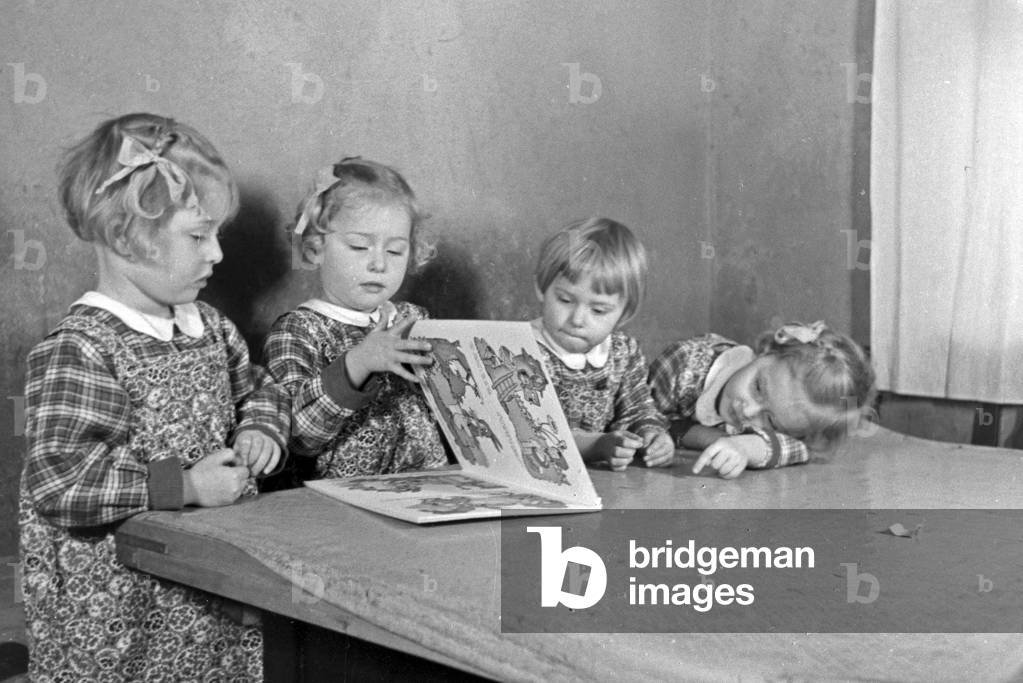 The Knipser's quadruplet girls with a storybook, Germany 1930s (b/w photo)