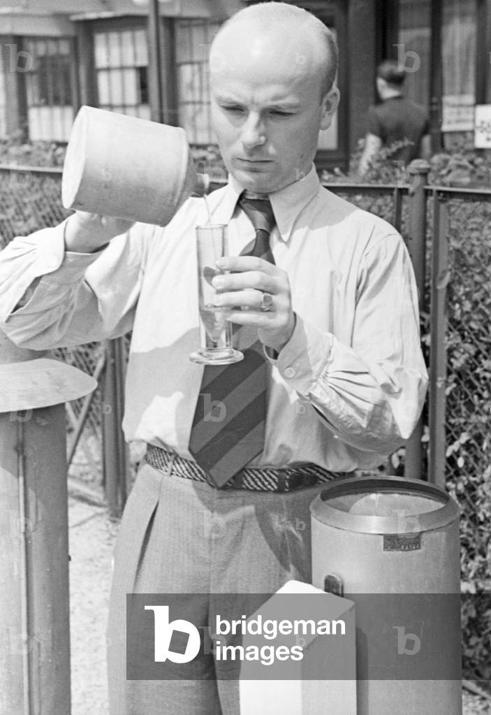Staff member of a meteorological office measuring the rainfall, Germany 1930s (b/w photo)