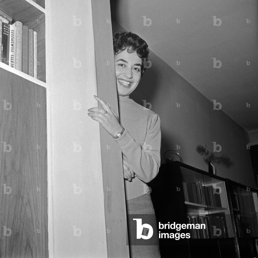 German looking behind a pillar in the living room, Germany 1950s
