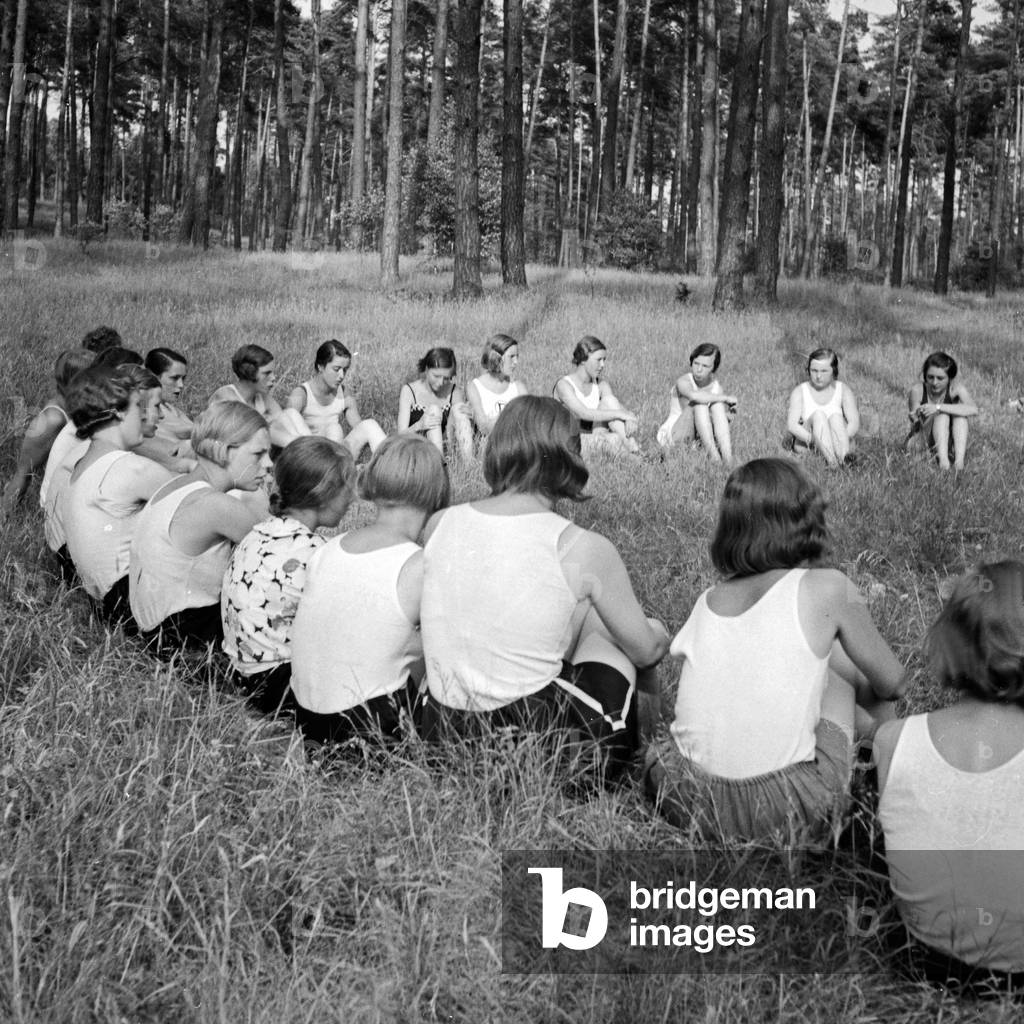 Girls are sitting in a circle in the forest at Altenhof, Brandenburg, 1930s (b/w photo)