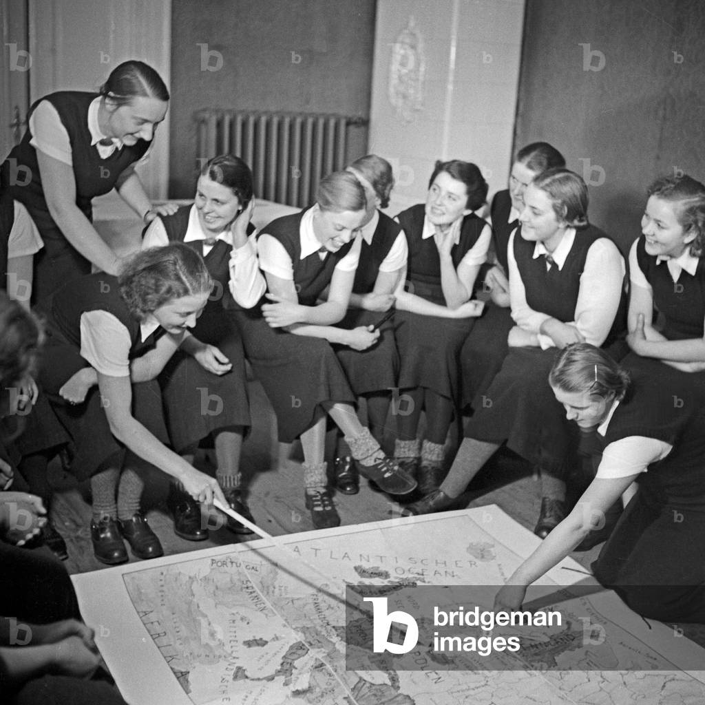 Women discussing a map of Europe in their ideological lesson at the female workforce group of Molkenberg, Germany 1930s (b/w photo)