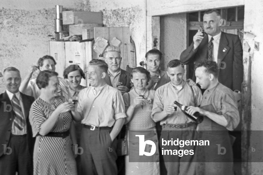 After the strawberry harvest celebrating with a drink at Buehl, Germany 1930s (b/w photo)