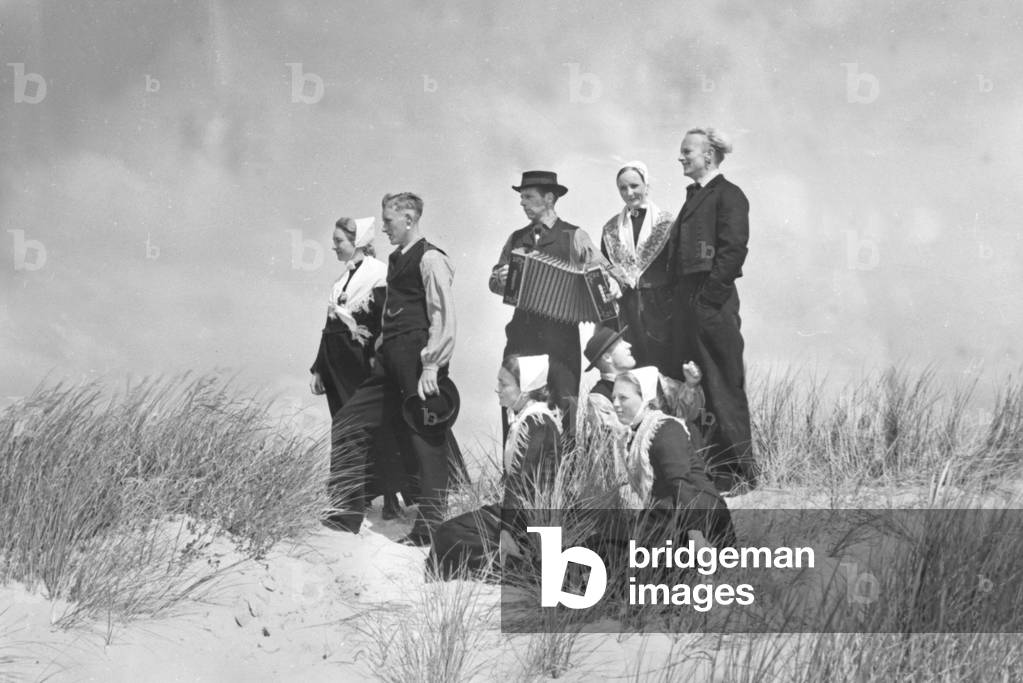 Four women and four men wearing array of the area around the city of Norddeich, Germany 1930s (b/w photo)