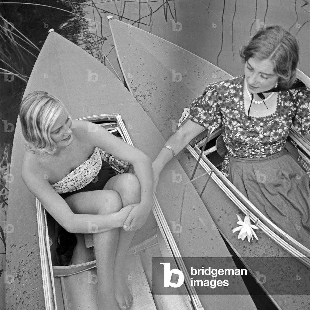 Two women in paddling boats on a lake, Germany 1930s (b/w photo)
