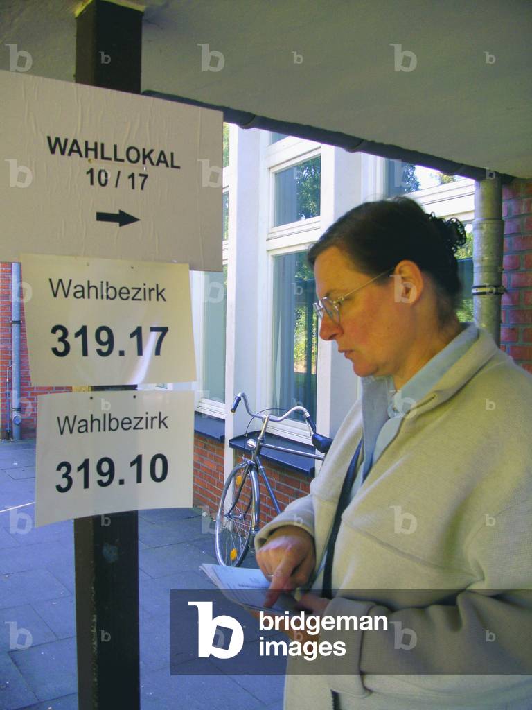 Germany , Hamburg , parliamentary elections 2009 , female voter is looking for the correct polling station , 27. 09. 2009. Keywords :