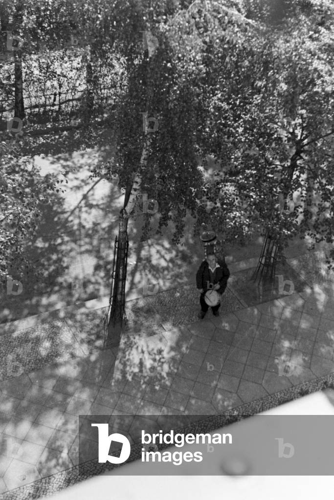 One-man-band playing at the courtyard, Germany 1930s (b/w photo)