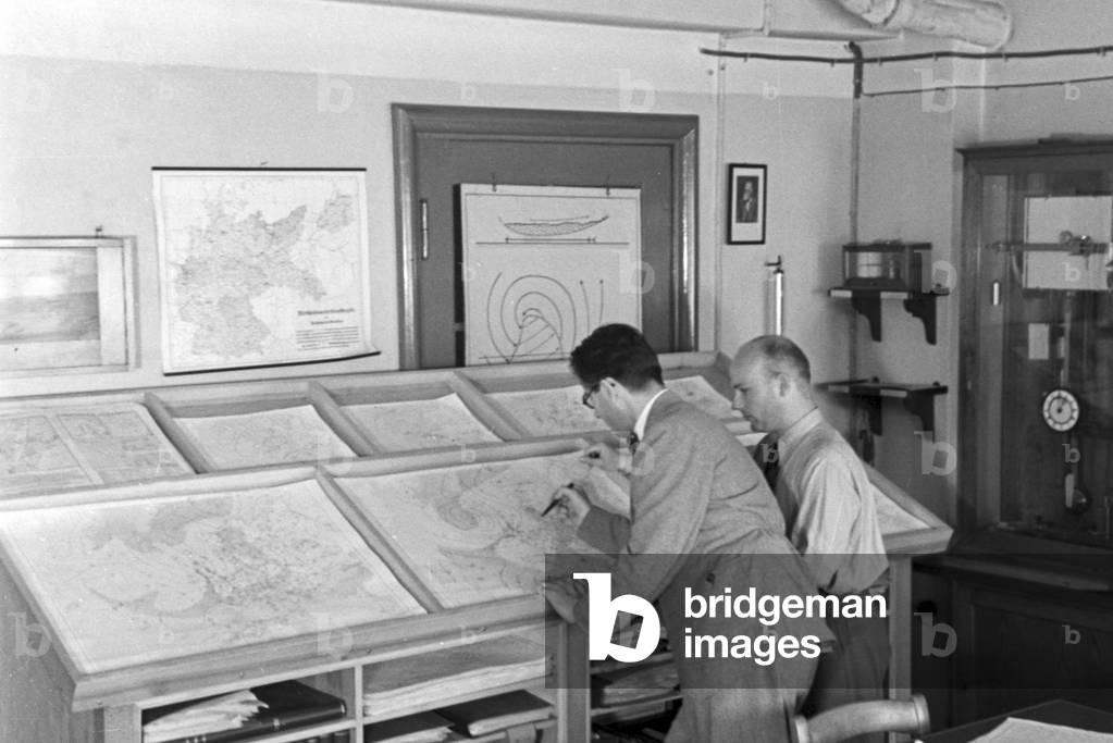 Staff member of a meteorological office drawing a card for a weather forecast, Germany 1930s (b/w photo)