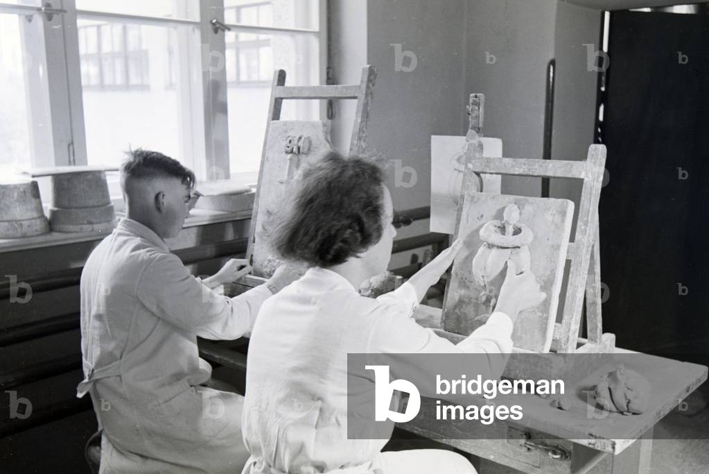 Students of the College for Ceramics working on reliefs in the working ateliers, Höhr-Grenzhausen, Germany 1930s (b/w photo)