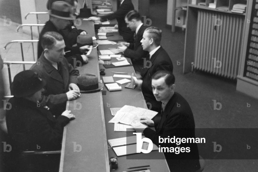 Travellers and staff members at a huge office of a travel agency in Berlin, Germany 1930s (b/w photo)