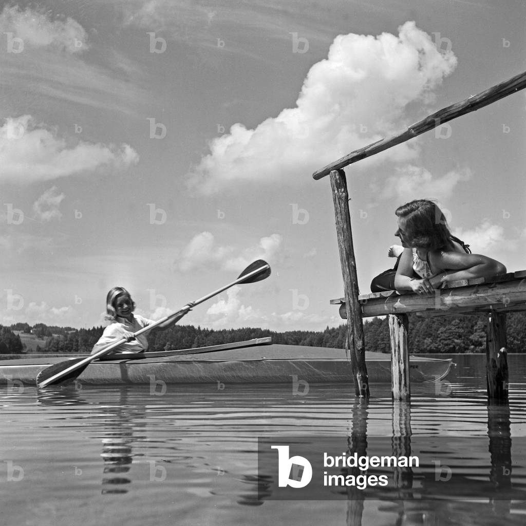 Two young women at a boardwalk on the shore of a lake in the Wachau area, Germany 1930s (b/w photo)