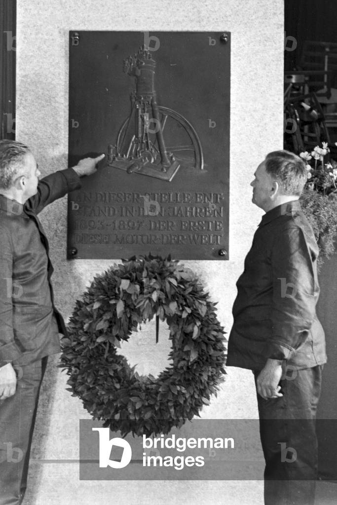 Staff members reading te memorial plate on the Diesel anniversary at the MAN factory at Augsburg, Germany 1930s (b/w photo)
