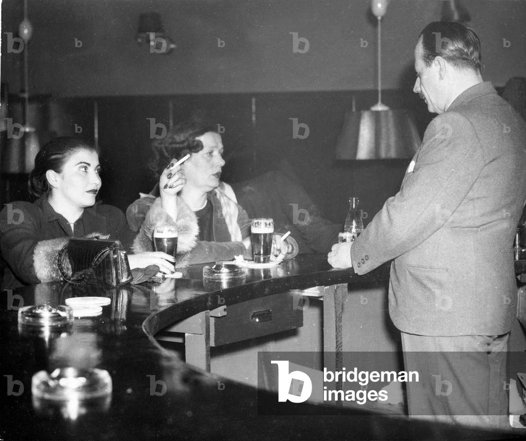 Two women at the counter in a bar at Hamburg Reeperbahn, 1950s (b/w photo)