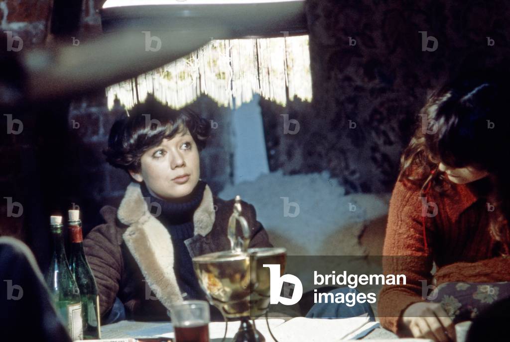 Two young women sitting together and having a glass of red wine, Germany 1970s
