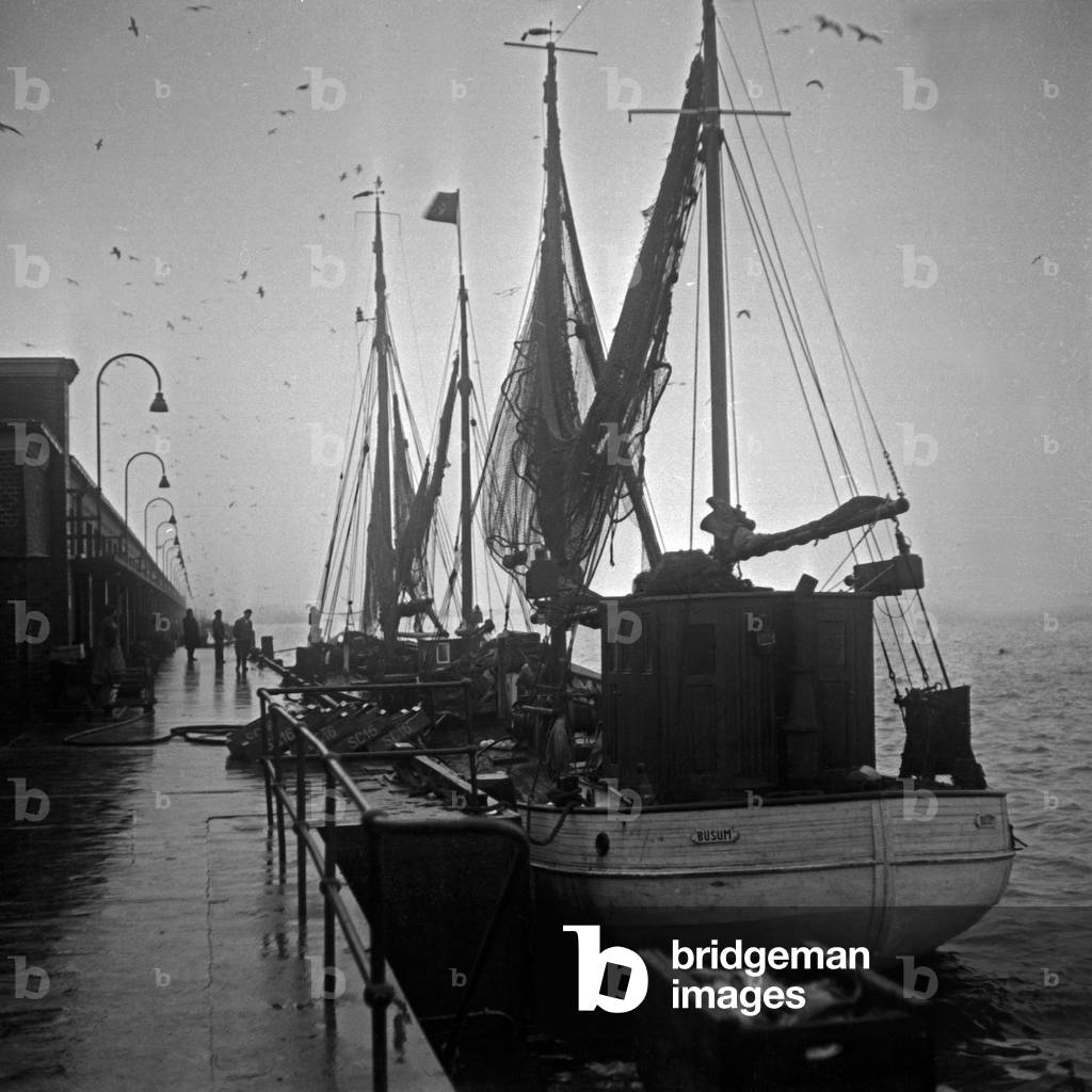 24 hours coverage live from fishing port Wesermuende, fish trawlers at the quay, Germany 1930s (b/w photo)