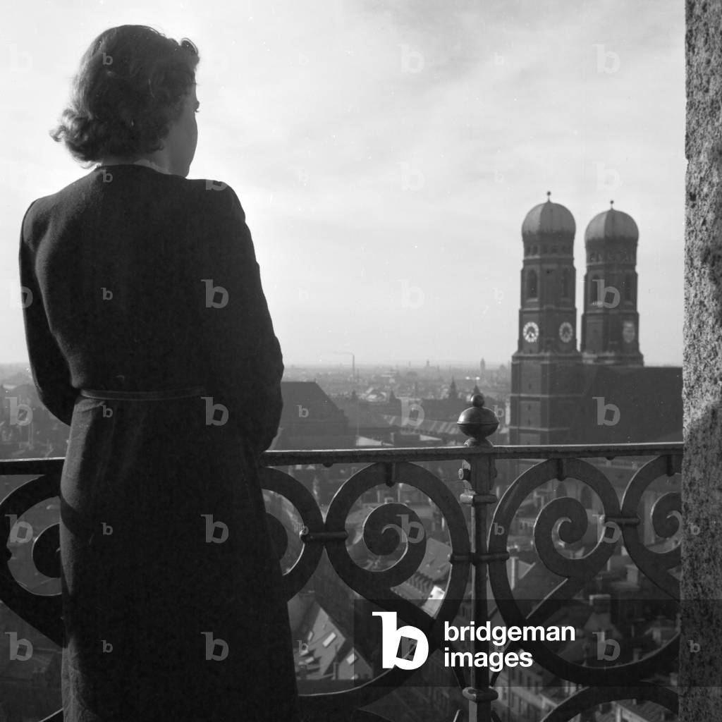 A woman standing on the top of a belfry at Munich, Germany 1930s (b/w photo)