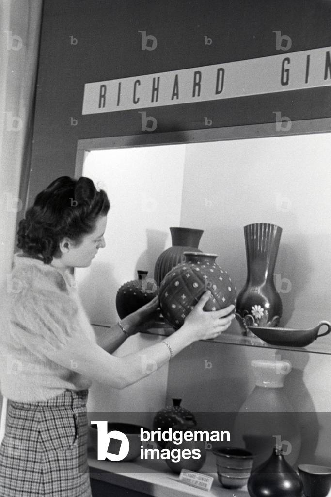 A visitor of the Leipziger Frühjahrsmesse in front of a stand of the porcelain factory Richard Ginori, Germany 1941 (b/w photo)