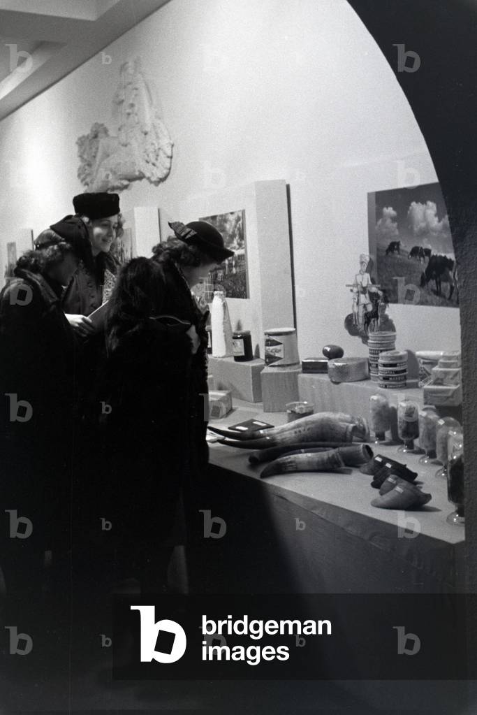 Visitors of the Leipziger Frühjahrsmesse in front of a Romanian stand with traditional products, Germany 1941 (b/w photo)