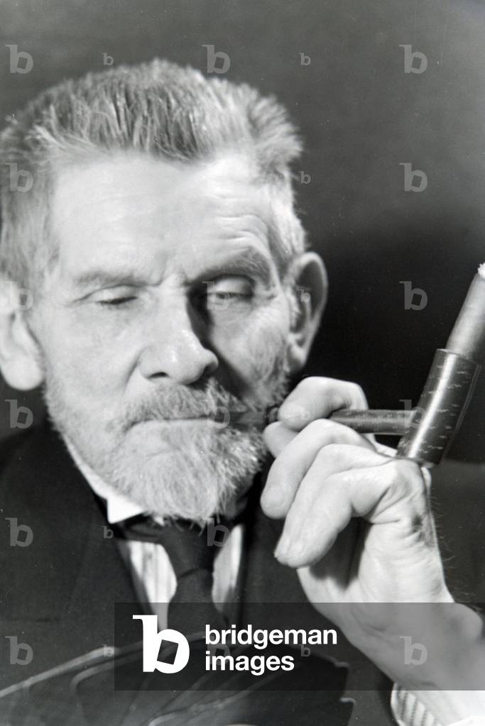 A man smoking a cigar for an advertising campaign, Germany 1930s (b/w photo)
