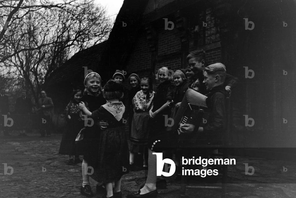 Children dancing in traditional costume of Ammerland near Bad Zwischenahn at the Oldenburg area, Germany 1930s (b/w photo)