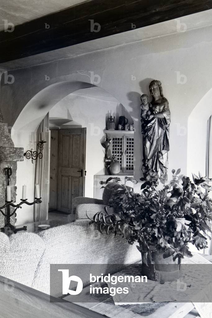 Living room with upholstery and a sculpture of Holy Mary and baby Jesus in Hartmannsberg castle, the residence of sculptor Josef Thorak, Germany 1930s (b/w photo)
