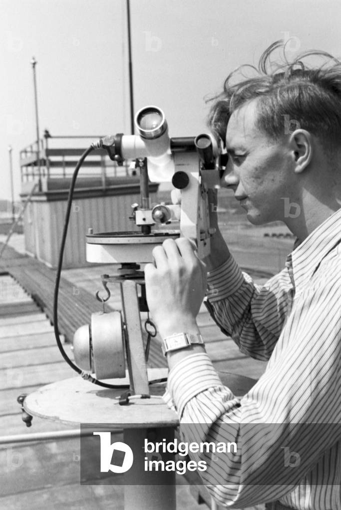 Staff member of a meteorological office calibrating analyser, Germany 1930s (b/w photo)