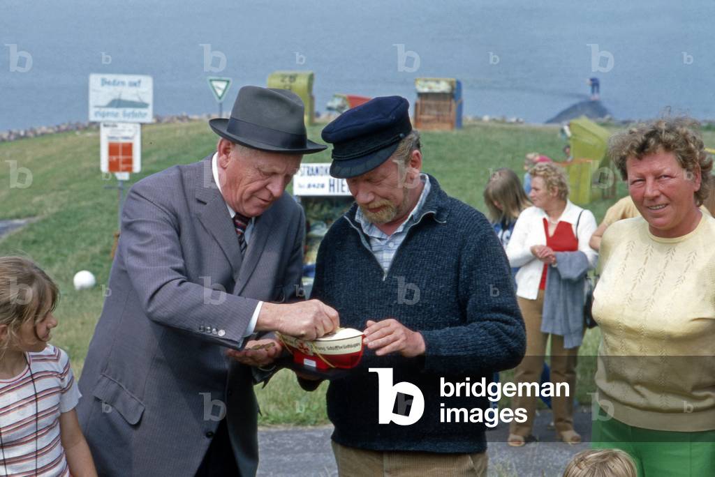 German actor Heinz Reincke raising donations for German Maritime Search and Rescue Service and colleague Gert Froebe donates, Germany late 1970s