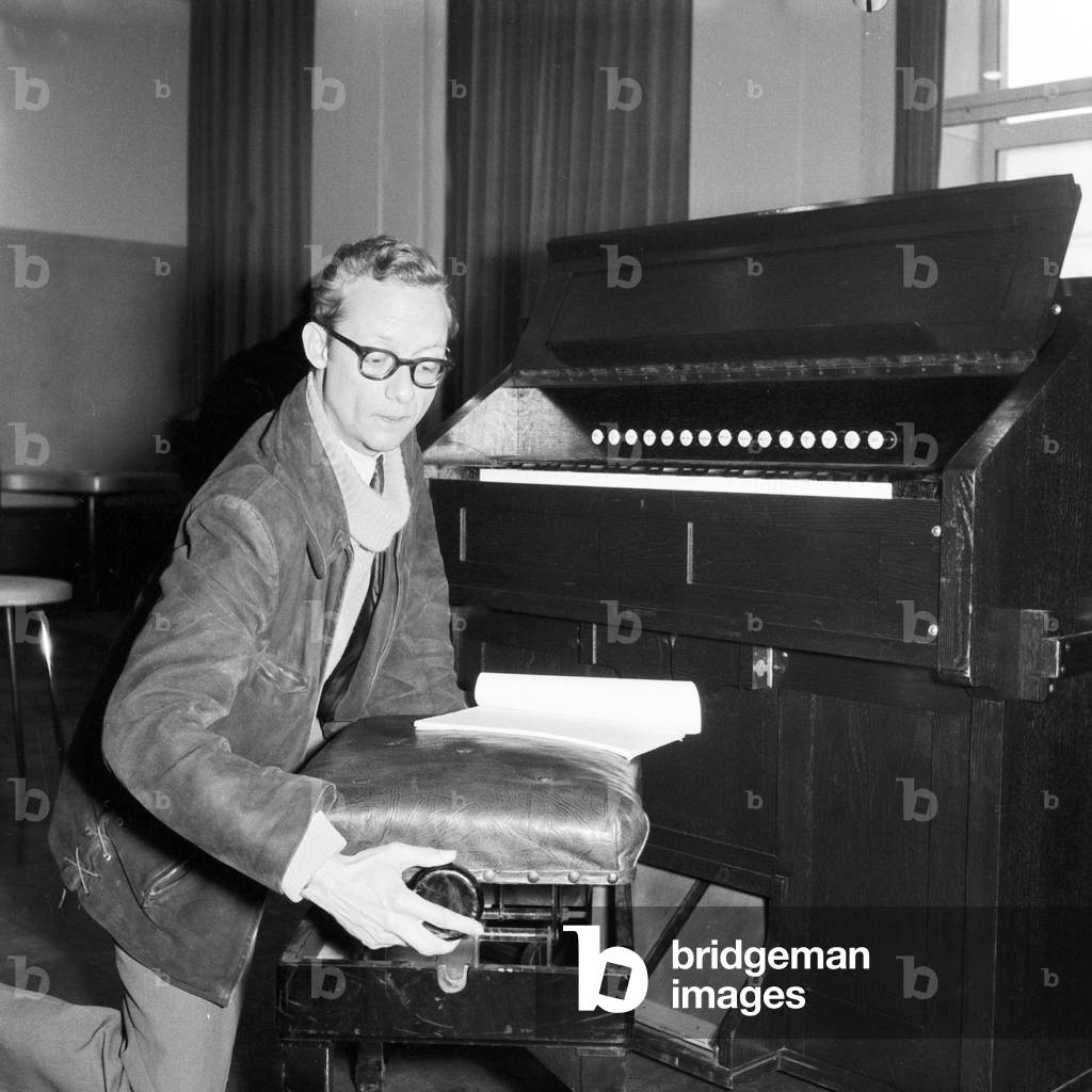A man regulating the height of a seat to play better the organ, Hamburg 1955