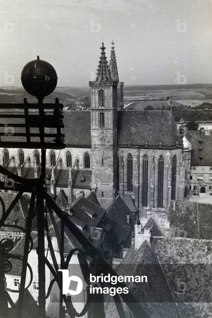 The highest tower of the townhall presents an excellent view of the parish church St Jakob in Rothenburg ob der Tauber and the surrounding natural landscapes, Germany 1930s (b/w photo)