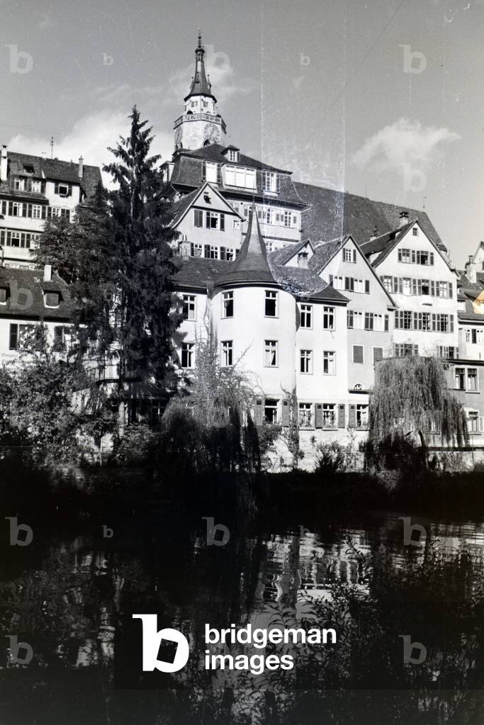 The facades of half-timbered houses along the Neckar with the collegiate church in the background in Tübingen, Germany 1930s (b/w photo)